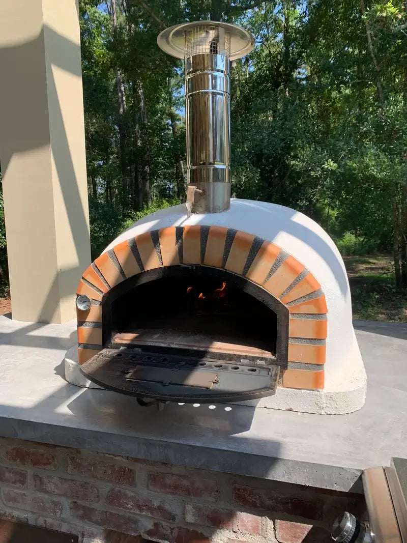 Stainless chimney cap with spark screen fitted on a 12 inch extension on a Pizzaioli Premium pizza oven under a covered patio