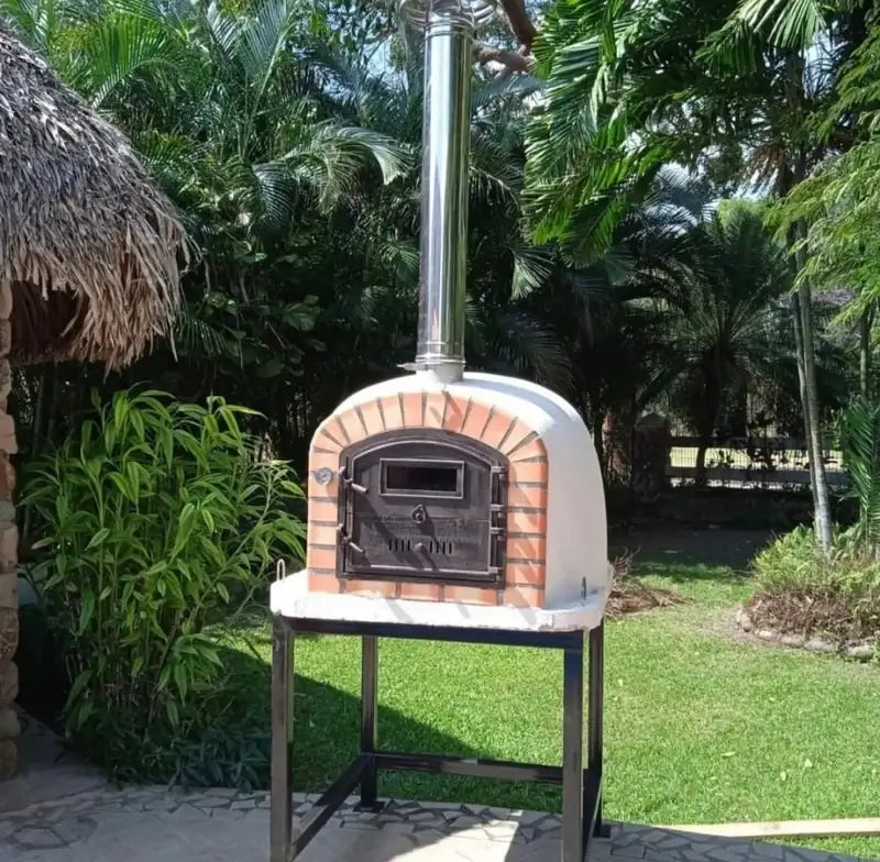 Lisboa Premium pizza oven with a stainless chimney extension pipe on a steel stand in a garden