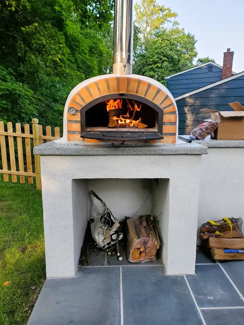 Pizzaioli Premium pizza oven built into a stucco base with a stainless chimney extension fitted