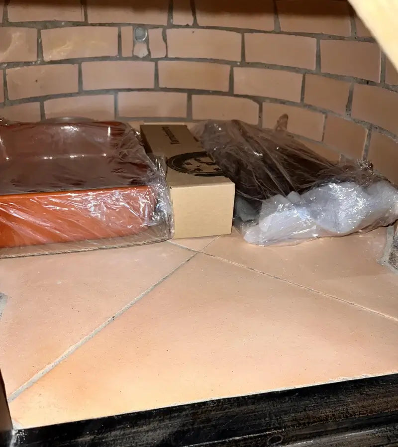Ceramic baking dish, thermometer, and Ultra Fire patch kit packed inside the Buena Ventura pizza oven as it arrives