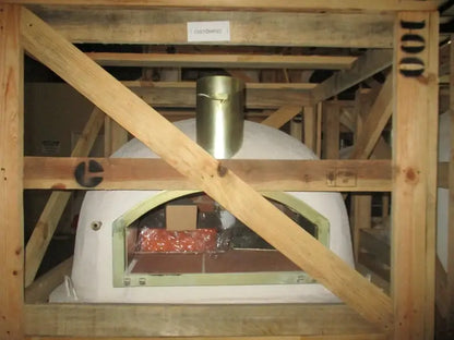 Builders custom Pizzaioli dome from Authentic Pizza Ovens as it arrives, bare white dome in its wooden crate with the chimney spout fitted and the door opening exposed