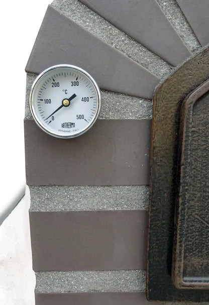Close up of the dial thermometer set in the cast stone brick pattern beside the Lume Largo Premium door