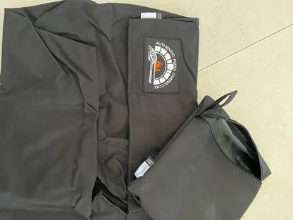 Maximus Mobile pizza oven cover laid out flat showing the Authentic Pizza Ovens logo patch beside its zip storage bag