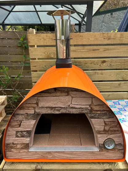 Orange Maximus Mobile pizza oven with the door removed, showing the arched mouth and the refractory tile cooking floor