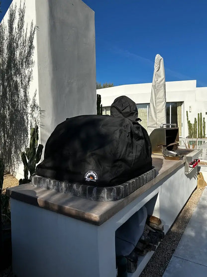 Authentic Pizza Ovens standard oven cover fitted over a white dome Lisboa brick pizza oven set into an outdoor kitchen counter