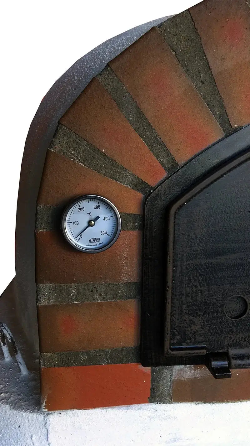 Close up of the 0 to 500°C dial thermometer set into the tumbled brick arch beside the cast aluminum door of a Pizzaioli Rustic Arch
