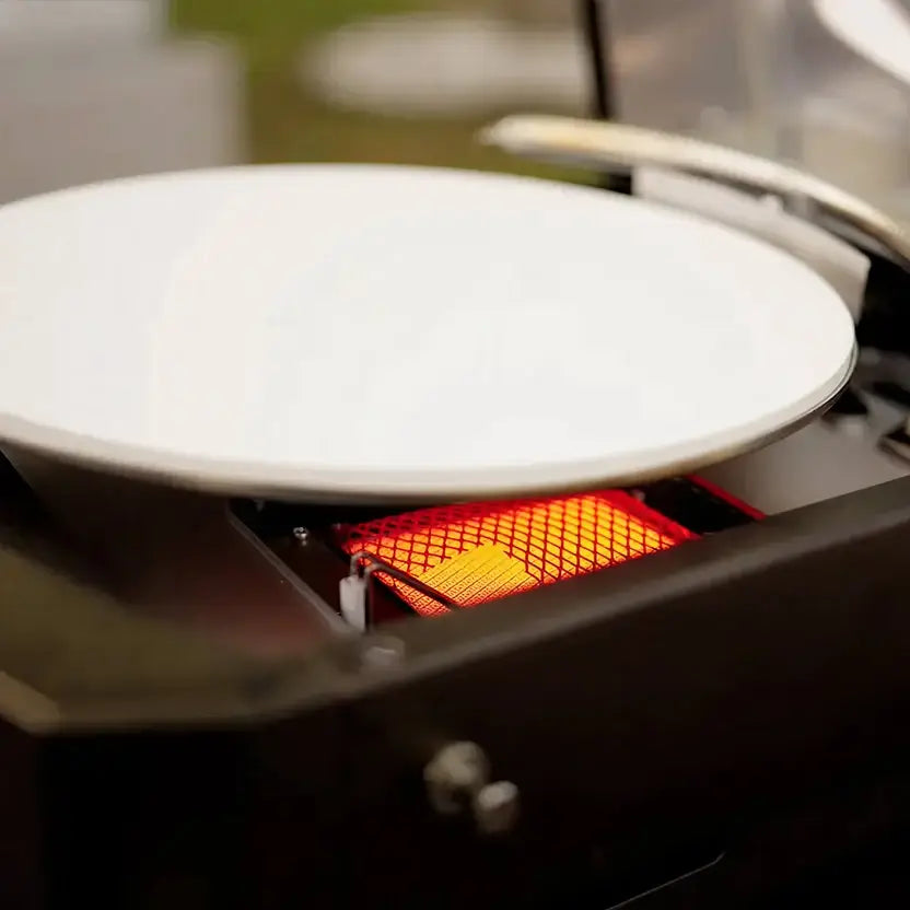 Infrared bottom burner glowing beneath the Halo Versa 16 rotating pizza stone