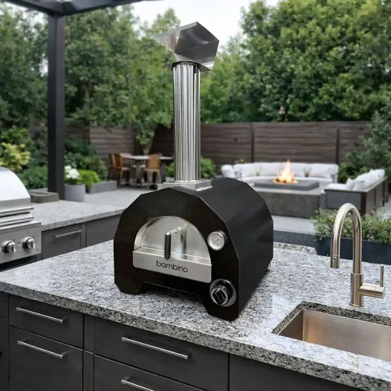 ItaliaForno Bambino compact gas pizza oven on a granite outdoor kitchen counter