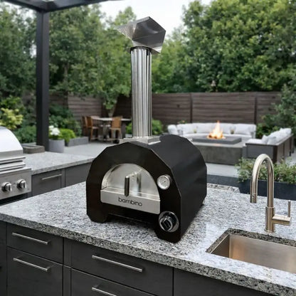 ItaliaForno Bambino compact gas pizza oven on a granite outdoor kitchen counter